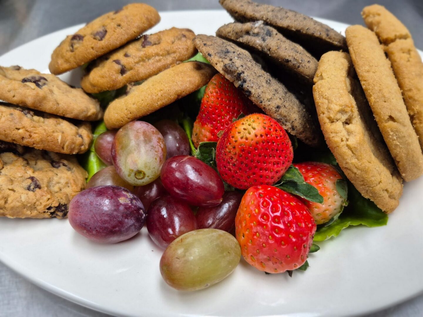 Cookies and fruit on a white plate