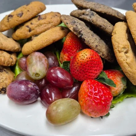 Assorted cookies with strawberries and grapes.