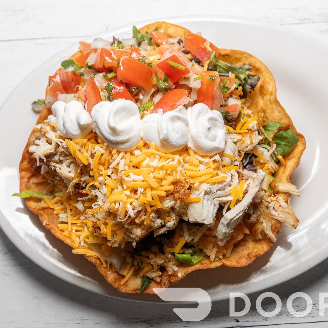 Tostada topped with cheese and tomatoes
